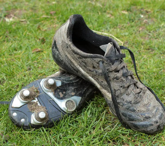 Dirty soccer cleats on grass