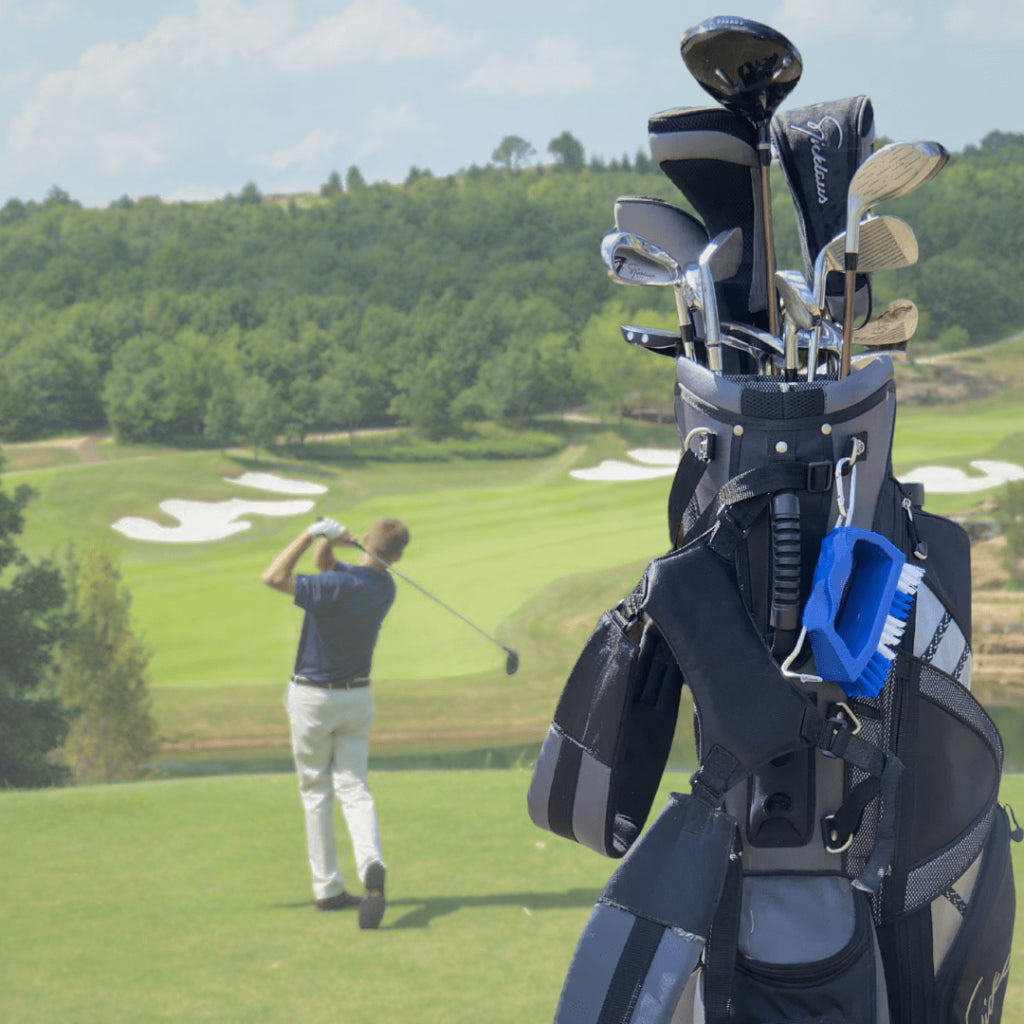 Golf bag with clubs on a golf course with a player in the background